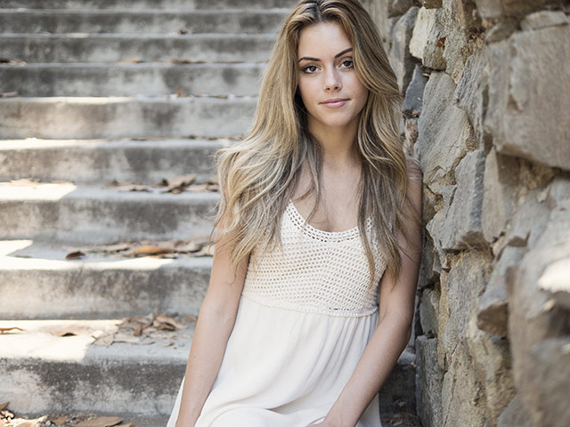 Woman standing next to a wall.