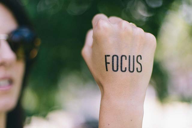 Woman with raised fist and "Focus" on back of hand