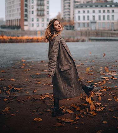 Woman in coat walking down street