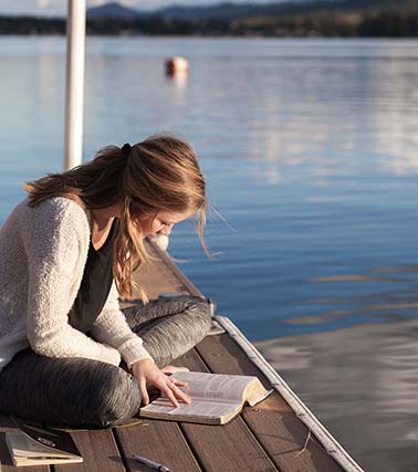 Woman readıng Bıble on dock