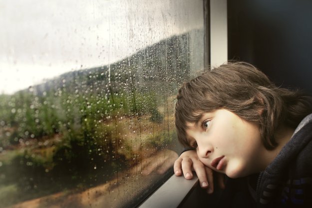 Boy leaning head and looking out window